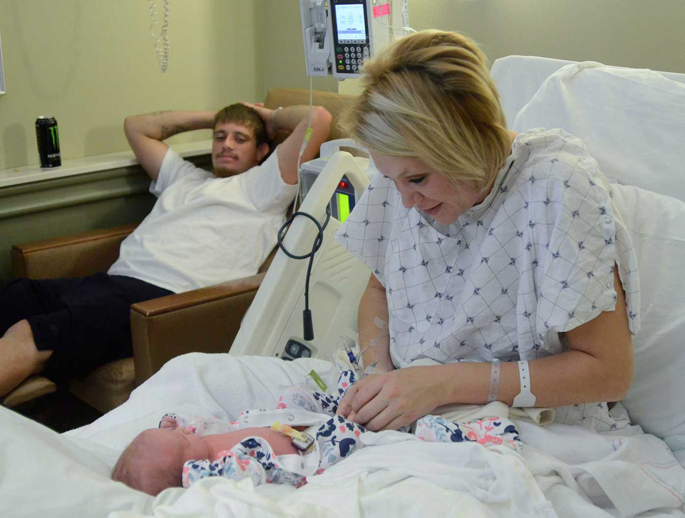 Stephanie dresses Journey as Justin looks on in her Hamilton Medical Center room.