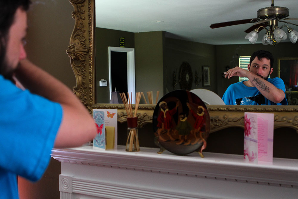 Ryan takes a look at himself in a mirror above the mantle in his mother's living room. He says he spends a lot of time thinking, these days.