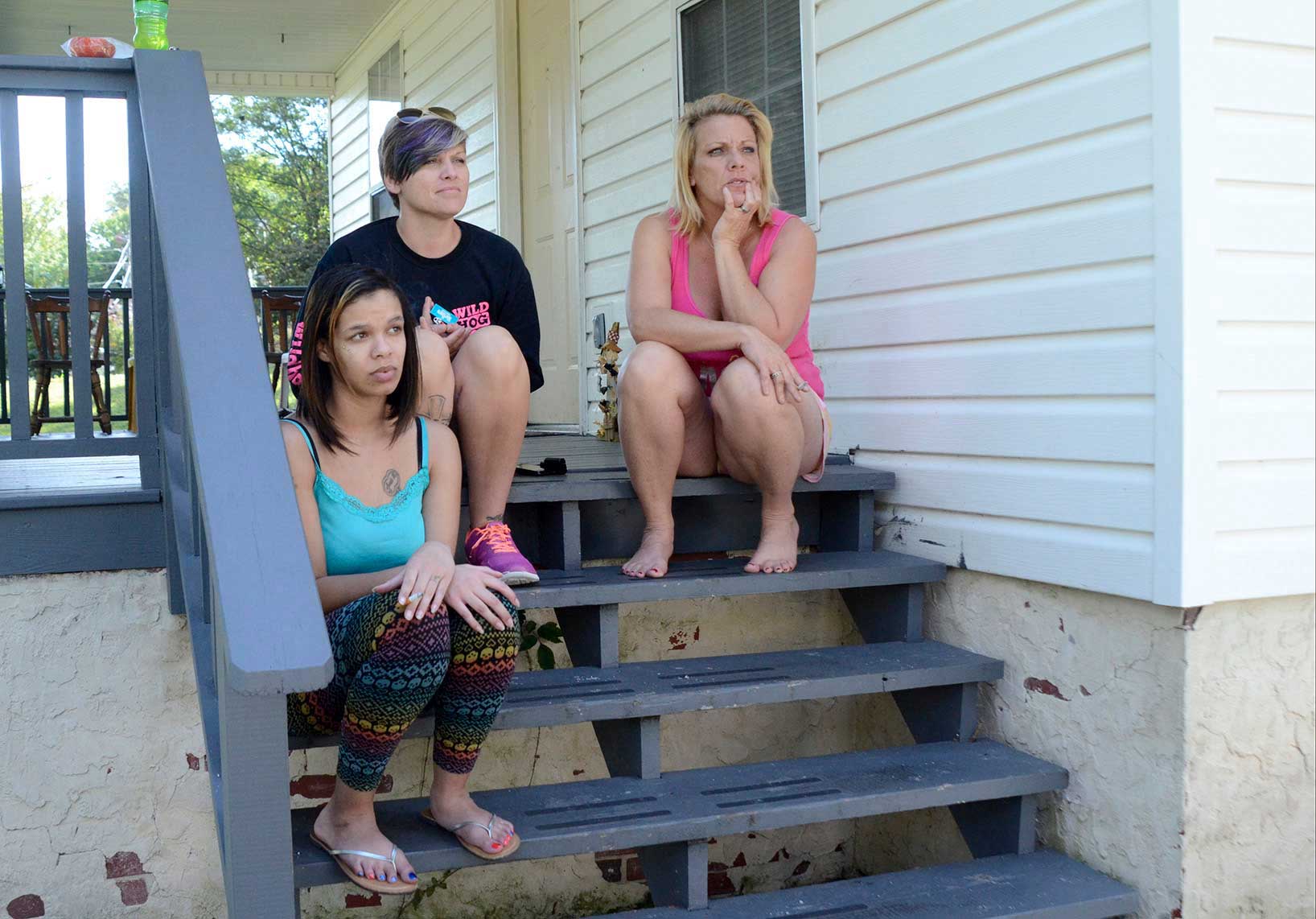 Dominique, Brooke and Crystal sit on the steps of the Carter Hope Center.