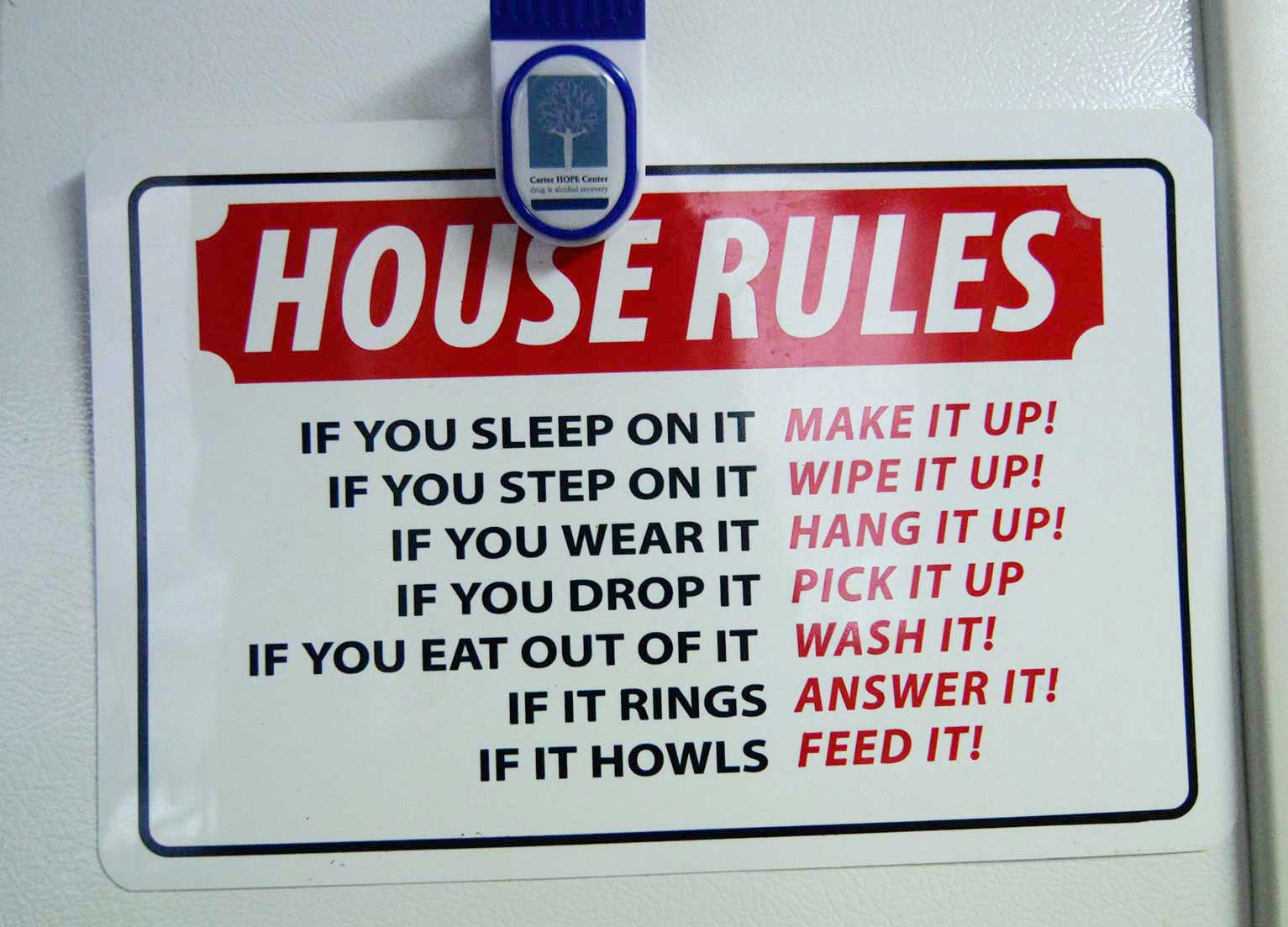 A list of house rules is posted on the refrigerator at the house.